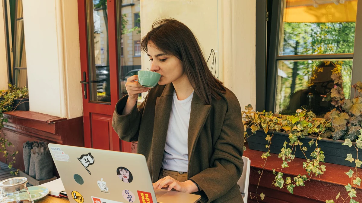 Personne travaillant sur un ordinateur portable à la terrasse d'un café, sur un réseau Wi-Fi public