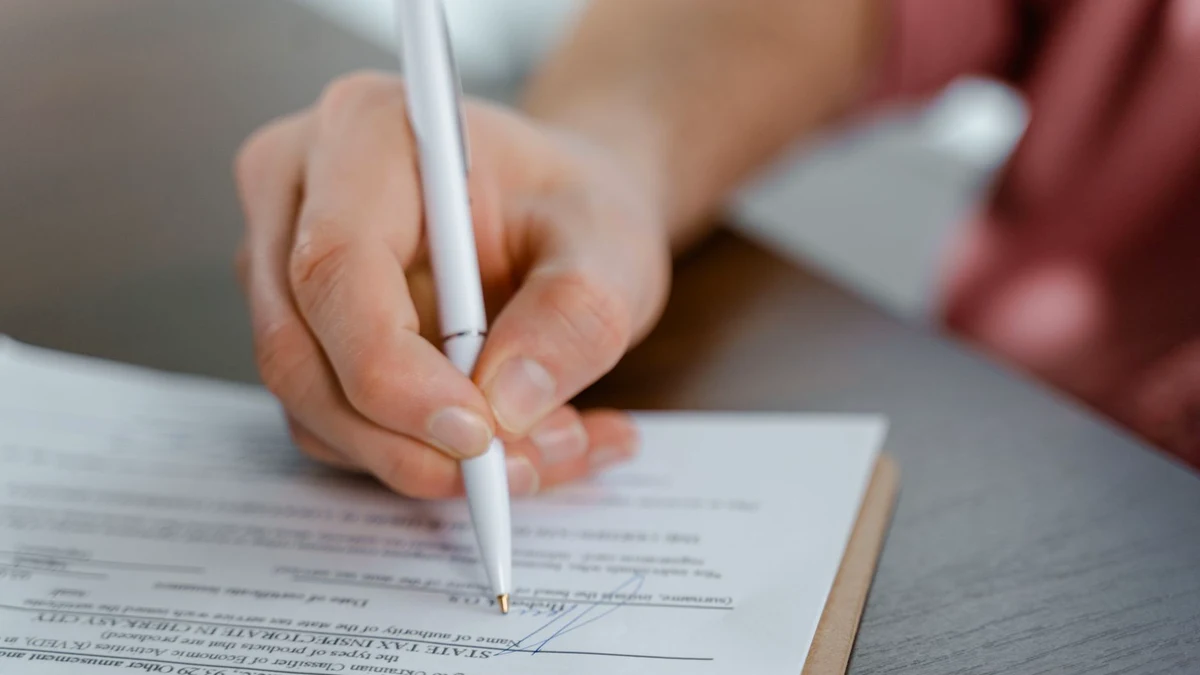Main signant un document officiel au stylo