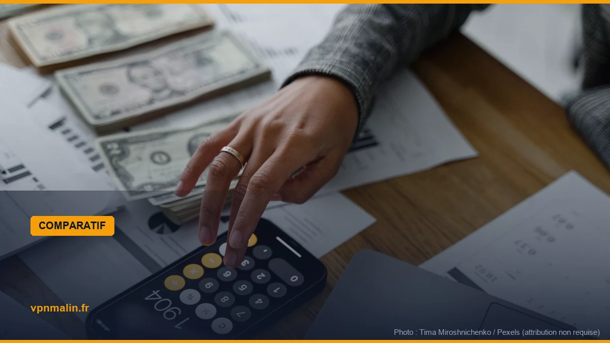 Main utilisant une calculatrice au-dessus de documents et de billets